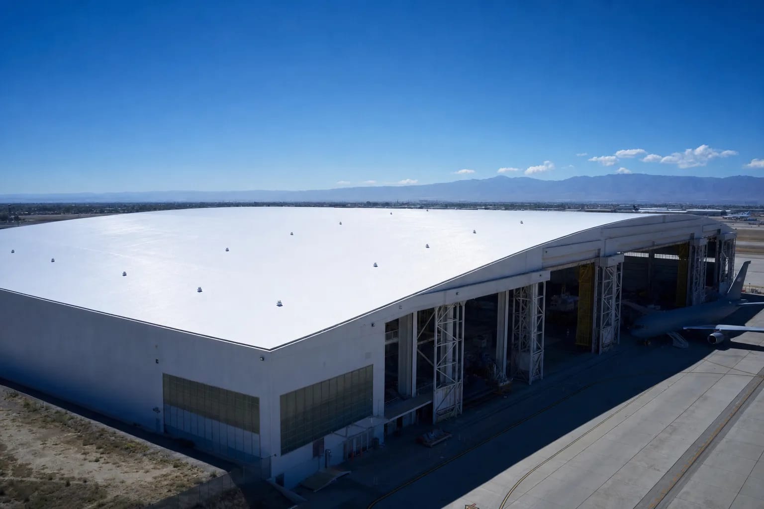 Grand hangar aéronautique avec toiture cool roof blanche réfléchissante